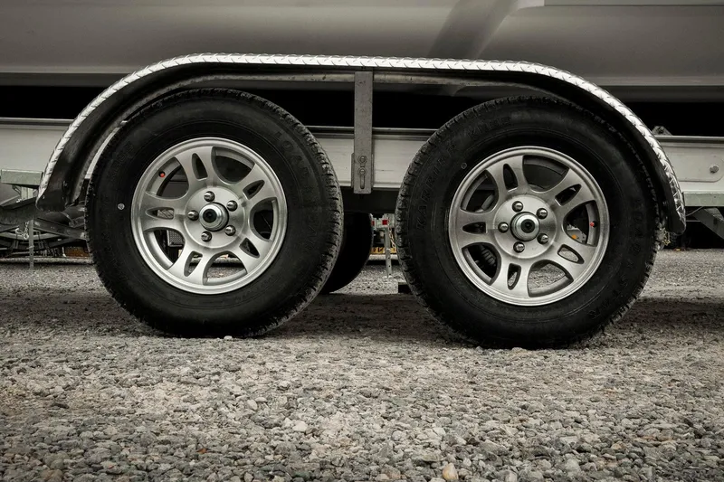 Slide: The Image of Trailer wheels of a 2026 Tidewater 2500 Carolina Bay boat on gravel. - 68