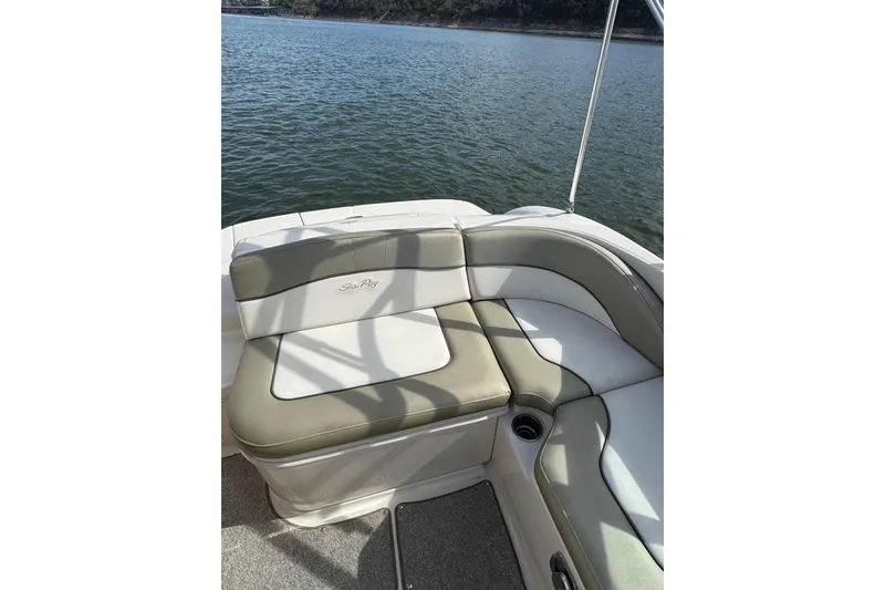 Slide: The Image of 2007 Sea Ray 200 Sundeck boat interior with cushioned seating by the water. - 11