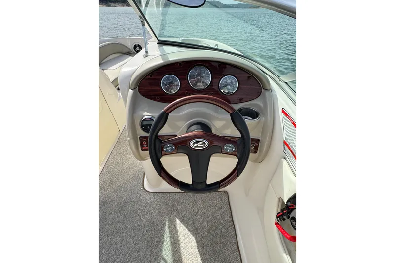 Slide: The Image of 2007 Sea Ray 200 Sundeck steering wheel and dashboard with lake view. - 13