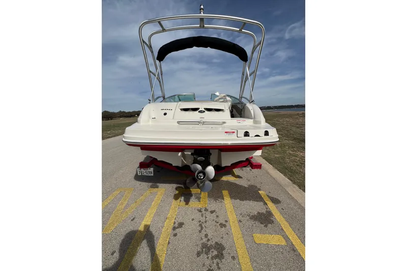 Slide: The Image of 2007 Sea Ray 200 Sundeck boat on trailer, rear view, parked near a lake. - 6