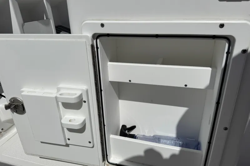 Slide: The Image of Open storage compartment on 2022 Sea Hunt Gamefish 25 boat, showing interior shelves. - 22