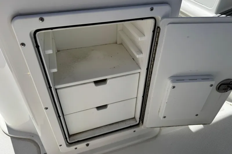 Slide: The Image of 2022 Sea Hunt Gamefish 25 storage compartment with open door and two drawers. - 24