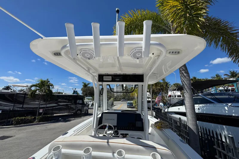 Slide: The Image of 2022 Sea Hunt Gamefish 25 boat with T-top and Garmin electronics, docked under palm trees. - 5