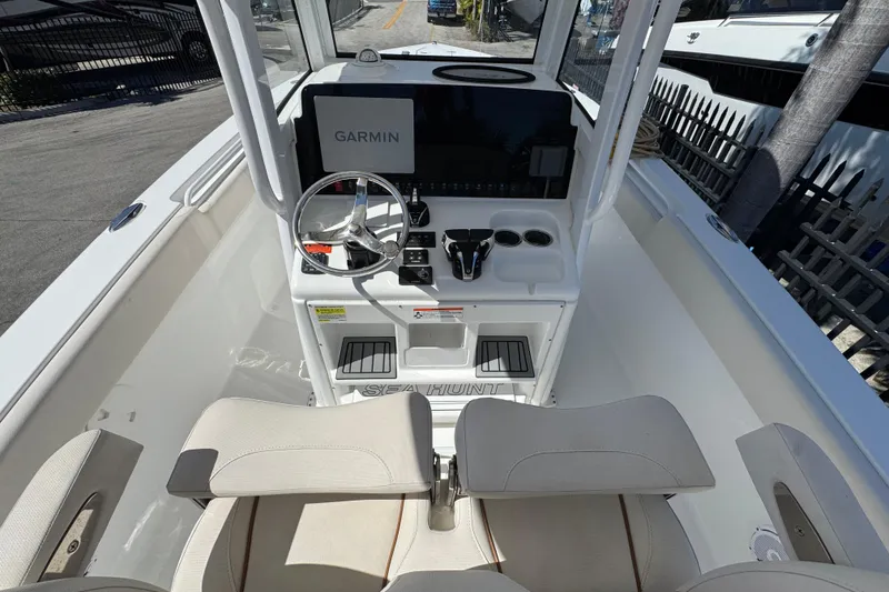 Slide: The Image of 2022 Sea Hunt Gamefish 25 boat interior with Garmin navigation system and steering wheel. - 6