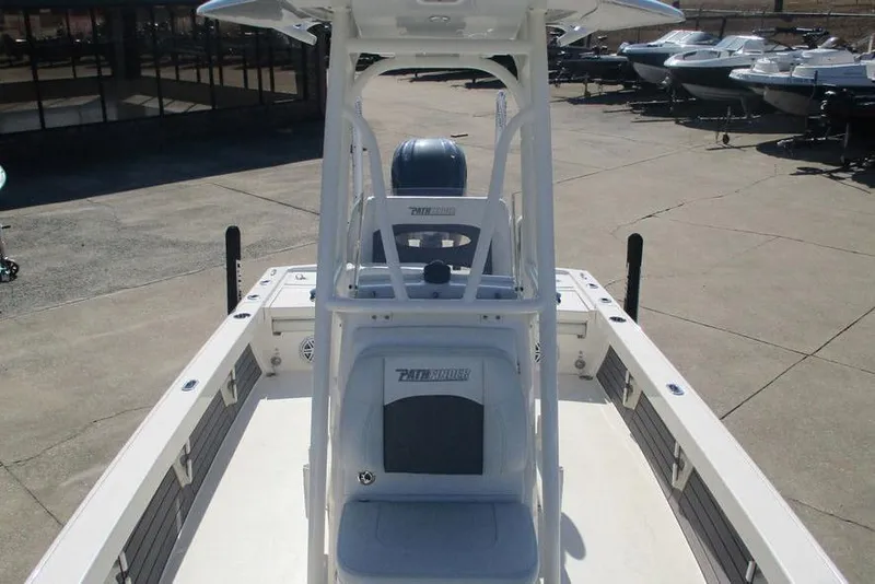Slide: The Image of 2023 Custom Pathfinder 2500 boat interior with seating and console, docked outdoors. - 13