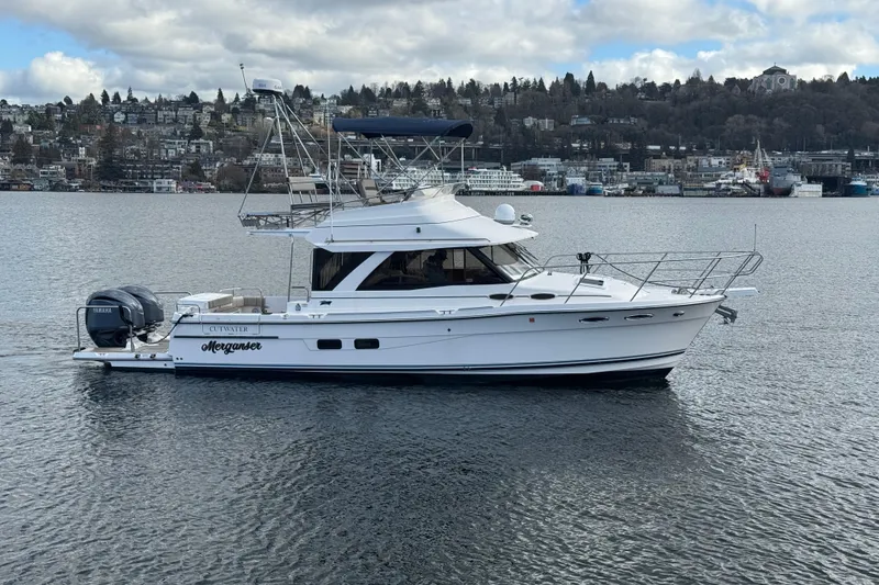 Slide: The Image of 2022 Cutwater C-32 CB yacht on calm water with cityscape background. - 0