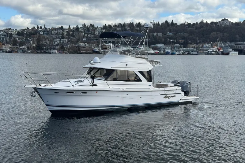 Slide: The Image of 2022 Cutwater C-32 CB boat on calm water with cityscape background. - 1