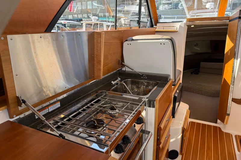 Slide: The Image of 2022 Cutwater C-32 CB boat interior with compact kitchen and cozy cabin. - 10
