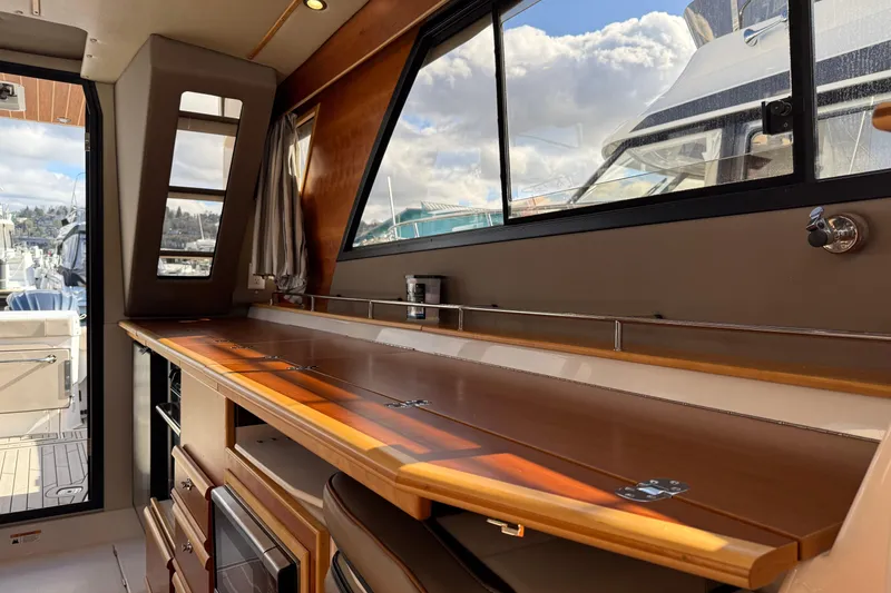 Slide: The Image of Interior of 2022 Cutwater C-32 CB boat with wooden cabinetry and large windows. - 11