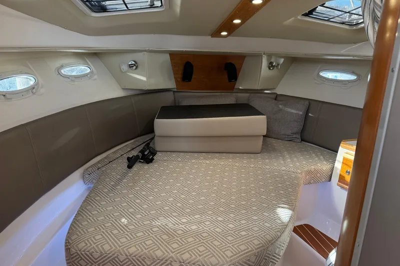 Slide: The Image of 2022 Cutwater C-32 CB cabin interior with cushioned seating and porthole windows. - 13