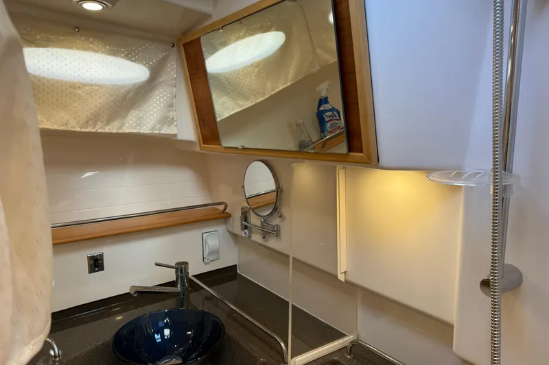 Slide: The Image of 2022 Cutwater C-32 CB bathroom with modern sink, mirror, and showerhead. - 17