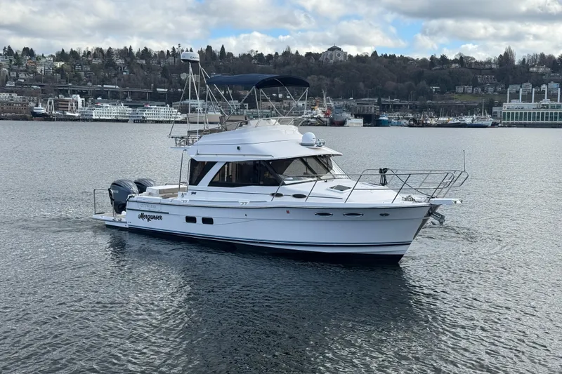 Slide: The Image of 2022 Cutwater C-32 CB yacht cruising on a calm waterway with cityscape background. - 30