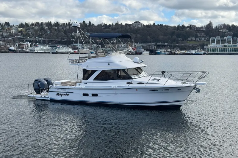 Slide: The Image of 2022 Cutwater C-32 CB yacht on calm water with cityscape background. - 32