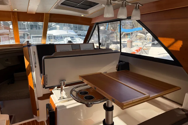 Slide: The Image of Interior of 2022 Cutwater C-32 CB boat with wooden table and seating. - 7