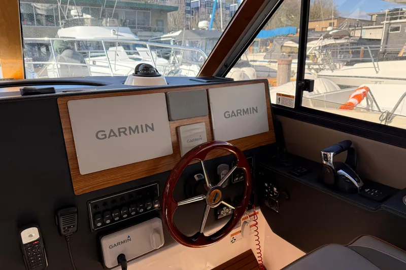 Slide: The Image of 2022 Cutwater C-32 CB helm with Garmin navigation, steering wheel, and control panel. - 8