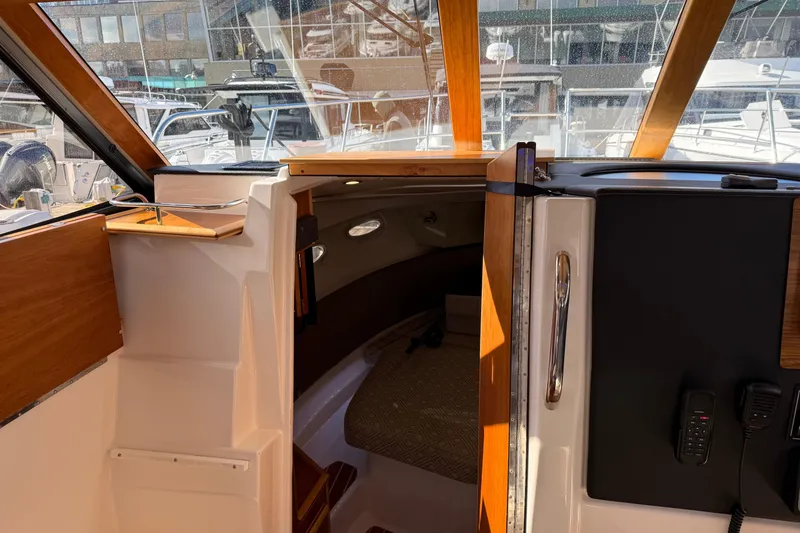 Slide: The Image of Interior view of 2022 Cutwater C-32 CB boat cabin with wood accents and seating area. - 9
