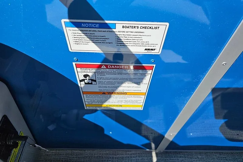 Slide: The Image of 2026 SunCatcher Select 22C boat safety and warning labels on blue surface. - 13