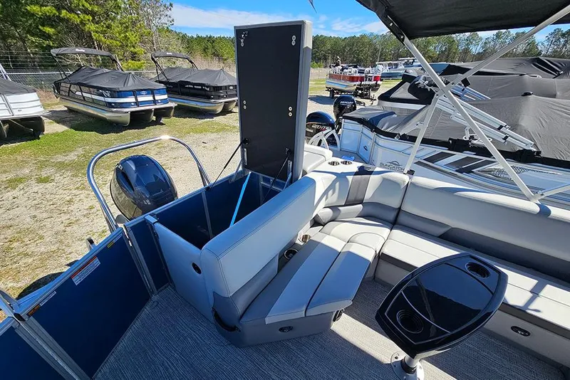 Slide: The Image of 2026 SunCatcher Select 22C pontoon boat interior with seating and storage, docked outdoors. - 9