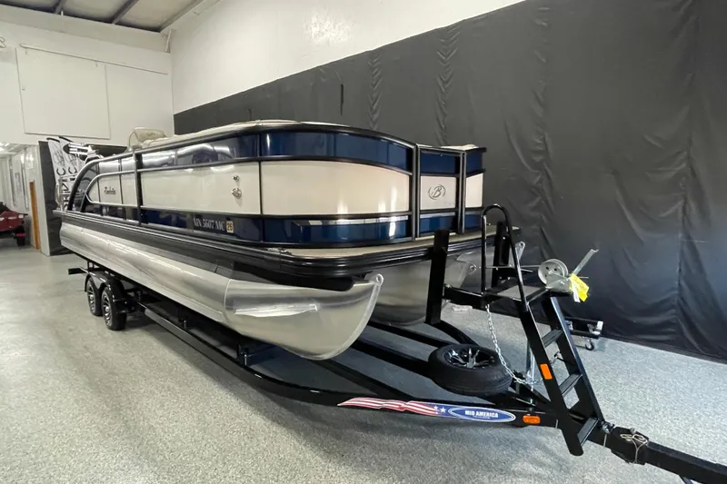 The Image of 2021 Barletta Lusso 25UC pontoon boat on trailer in indoor showroom. - 0