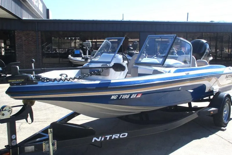 Slide: The Image of 2013 Nitro Z-7 boat on trailer, blue and white, parked outside dealership. - 7