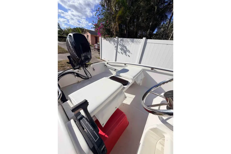 Slide: The Image of 2016 Boston Whaler 130 Super Sport boat interior with Mercury engine, sunny day. - 10