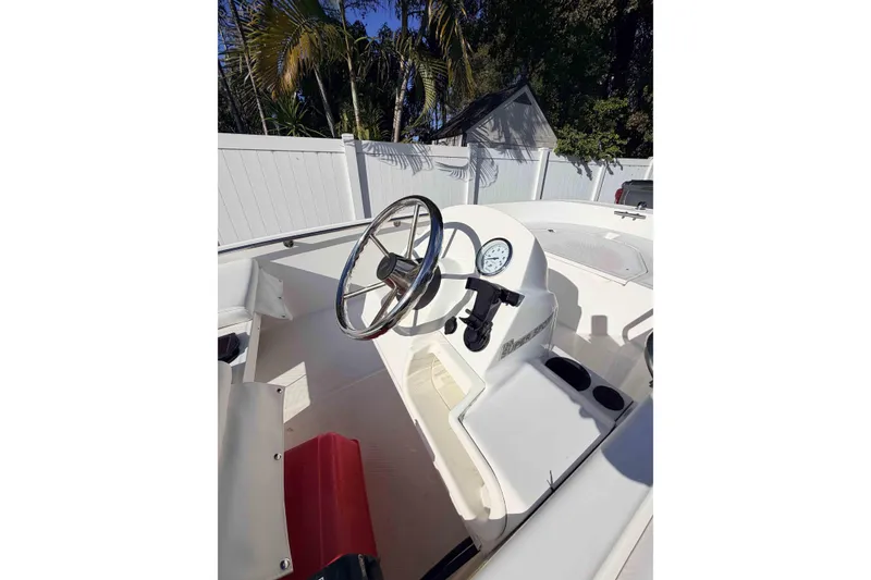 Slide: The Image of 2016 Boston Whaler 130 Super Sport boat interior with steering wheel and gauge. - 12