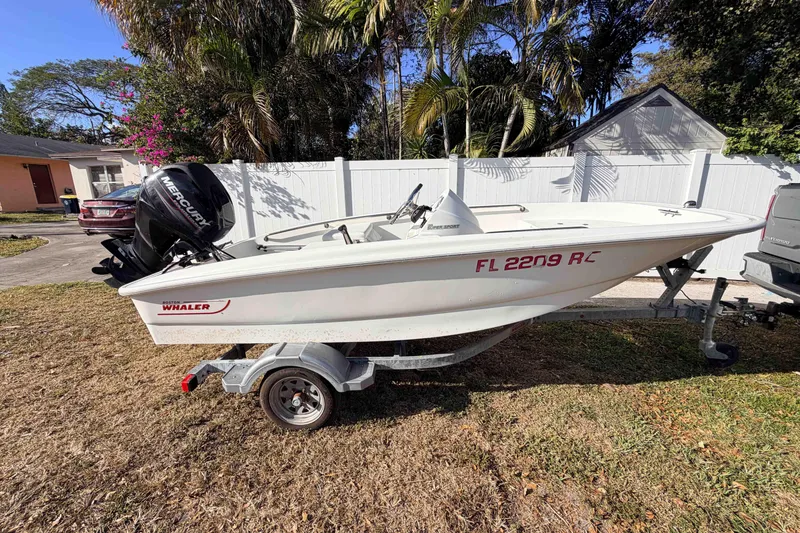 Slide: The Image of 2016 Boston Whaler 130 Super Sport boat on trailer, parked outdoors. - 9