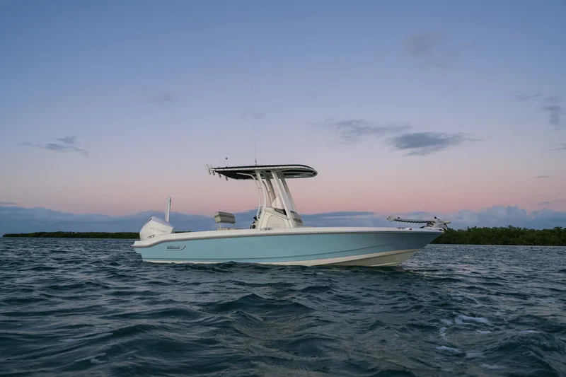 Slide: The Image of Boston Whaler 220 Dauntless 2026 on calm water at sunset. - 21