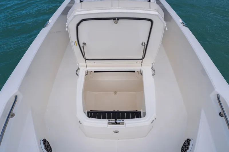 Slide: The Image of Boston Whaler 220 Dauntless 2026 with open storage compartment on water. - 35