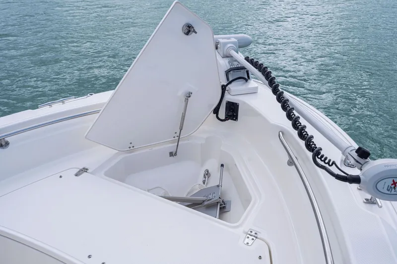 Slide: The Image of Boston Whaler 220 Dauntless 2026 with open anchor locker on water. - 44