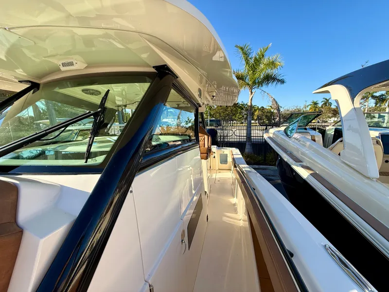 Slide: The Image of Scout 377 LXF 2023 boat with sleek design and palm trees in background. - 15