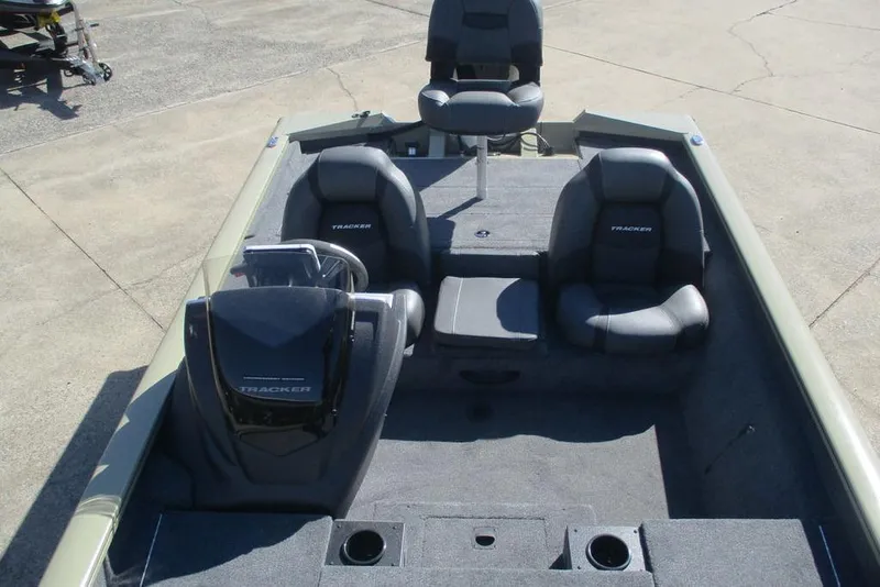 Slide: The Image of 2026 Tracker Pro Team 190 boat interior with seating and console, parked on concrete. - 7