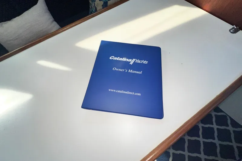 Slide: The Image of Blue Catalina Yachts owner's manual on a white table, 1987 Catalina 30 MkII. - 31
