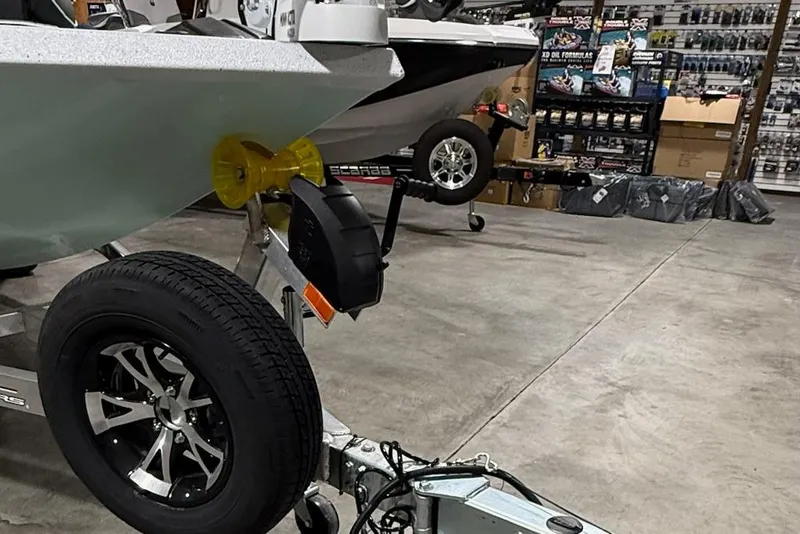 Slide: The Image of 2026 Express H20 Bay boat on trailer in showroom with accessories displayed. - 10