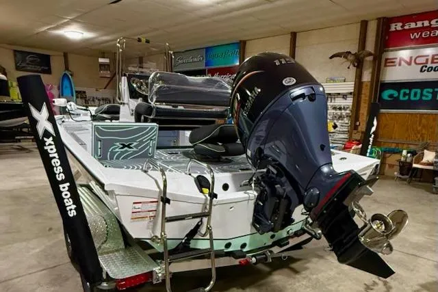 Slide: The Image of 2026 Express H20 Bay boat with powerful outboard motor in showroom setting. - 5