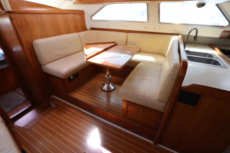 Slide: The Image of Interior of 2007 Catalina Morgan 440 yacht with wooden dining area and beige seating. - 39
