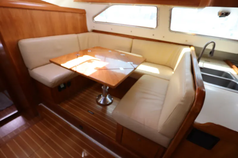 Slide: The Image of Luxurious 2007 Catalina Morgan 440 yacht interior with wooden dining area and beige seating. - 40