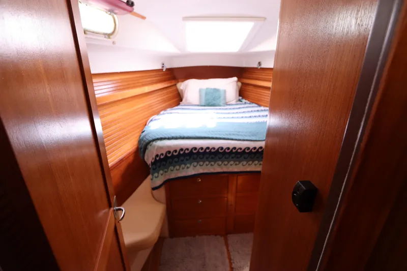 Slide: The Image of Cozy cabin interior of 2007 Catalina Morgan 440 sailboat with wooden finish and bed. - 44