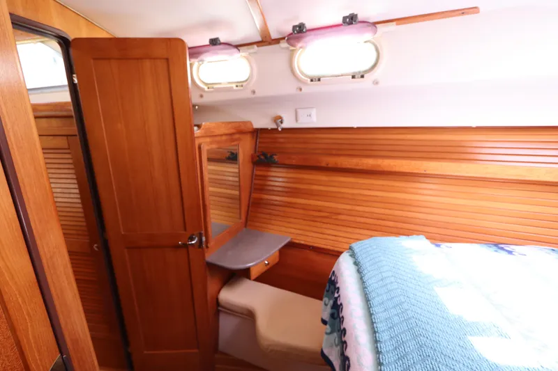 Slide: The Image of Cozy cabin interior of 2007 Catalina Morgan 440 sailboat with wooden paneling and bedding. - 45