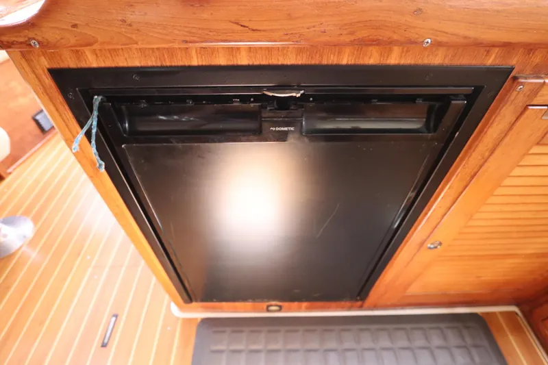 Slide: The Image of Dometic fridge in 2007 Catalina Morgan 440 yacht interior, wooden cabinetry. - 52
