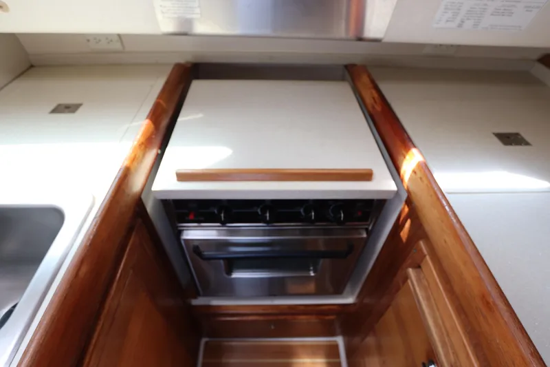 Slide: The Image of 2007 Catalina Morgan 440 yacht kitchen with stove and wooden cabinetry. - 55