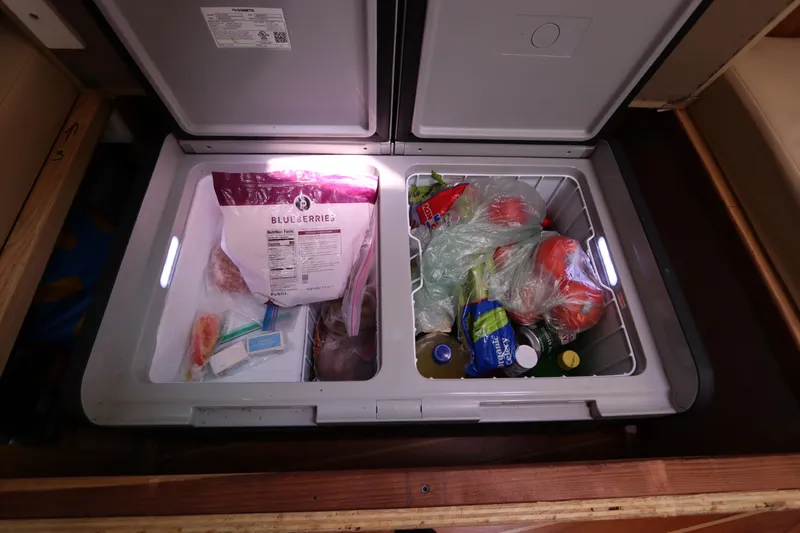 Slide: The Image of Open refrigerator on Catalina Morgan 440 yacht, displaying assorted groceries and frozen blueberries. - 60