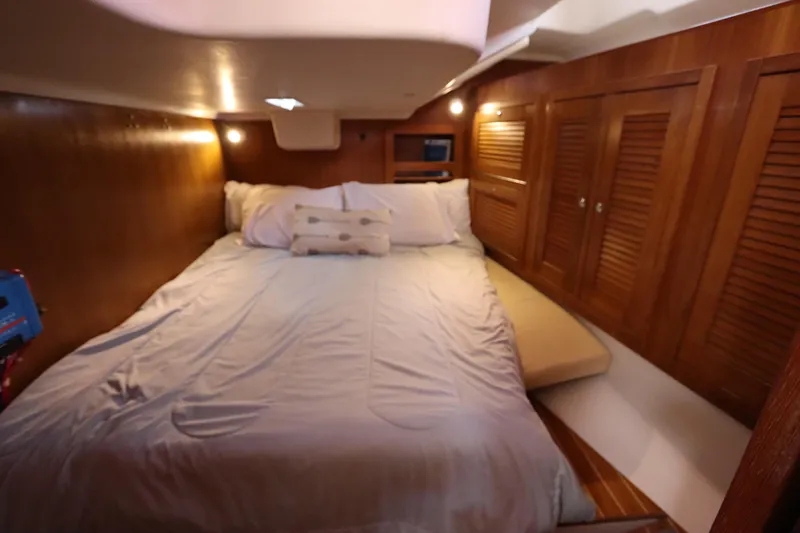 Slide: The Image of Cozy cabin interior of 2007 Catalina Morgan 440 sailboat with wooden paneling and comfortable bedding. - 64