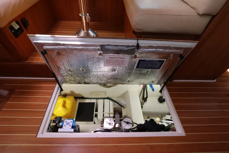 Slide: The Image of Engine compartment of a 2007 Catalina Morgan 440 sailboat, featuring insulated hatch and equipment. - 72