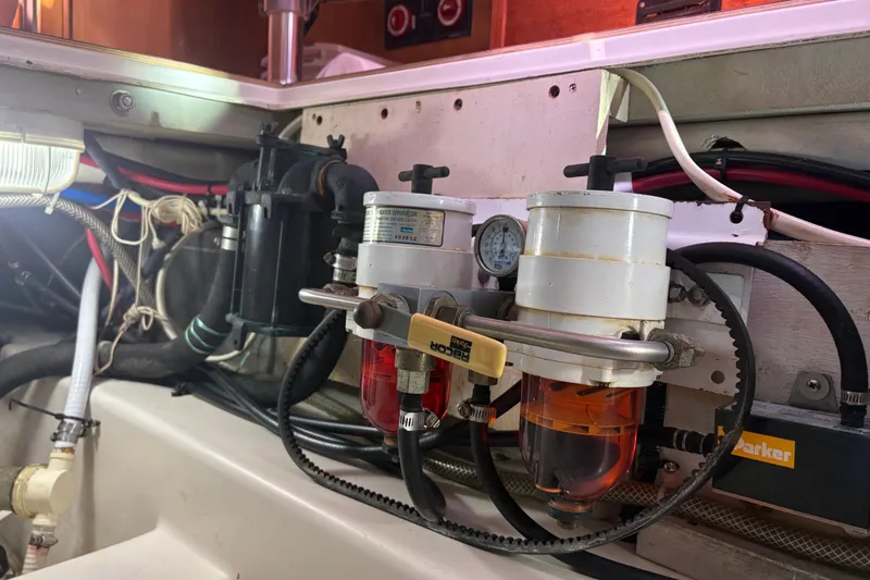 Slide: The Image of Engine compartment of a 2007 Catalina Morgan 440 sailboat, featuring fuel filters and hoses. - 76