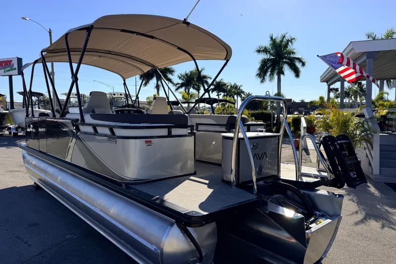 Slide: The Image of 2026 Avalon 2385 LSZ Quad Lounger Tri Toon boat with canopy, parked outdoors. - 7