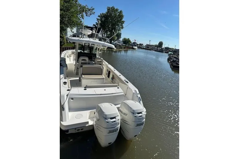 Slide: The Image of 2016 Boston Whaler 330 Outrage with twin outboard engines on a river. - 3