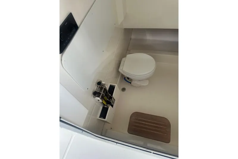 Slide: The Image of 2016 Boston Whaler 330 Outrage boat interior with toilet and storage compartment. - 8