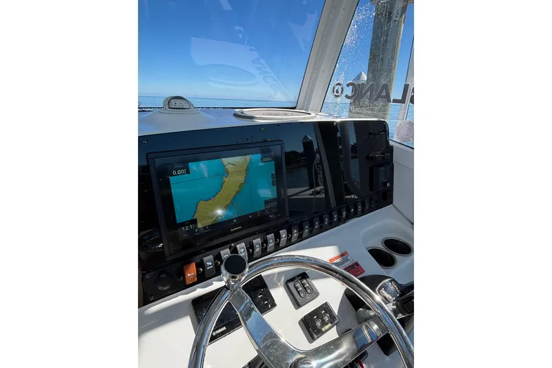 Slide: The Image of 2018 Sea Hunt Gamefish 25 dashboard with navigation display and steering wheel. - 11