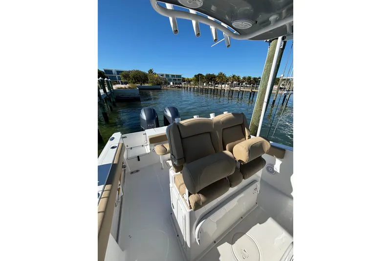 Slide: The Image of 2018 Sea Hunt Gamefish 25 boat with dual engines docked in a sunny marina. - 12